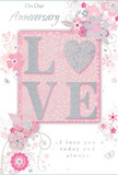 This softly romantic anniversary card unfolds like a paper bouquet, its design built around the raised, glitter-brushed word LOVE that glows gently from the centre. The letters stand out in subtle relief, creating a tactile sensation much like tracing the contours of a ribbon on a hand-tied arrangement. The colour palette is muted and harmonious: a base of blush pink is gently diffused with pearly whites and light greys, and throughout the card, delicate silver accents add a quiet, sophisticated glimmer. Encircling the central word, airy swirls of stylised flowers and foliage arc gracefully across the surface, reminiscent of a florist's quick pencil sketches on an order pad in an Elm Park workshop. The blossoms themselves are simplified yet elegant, brushed in shades of pale rose, ivory and soft grey, with filigree lines suggesting petals, leaves and slender stems weaving in and out of each other. Fine scrolling tendrils and gentle loops fill the corners and edges without overwhelming the design, preserving a sense of openness and light. Between the floral motifs, an anniversary message unfolds in a flowing script, its curves echoing the same organic shapes as the vines and petals. The overall mood is serene and heartfelt, a quiet celebration of shared years and cherished memories. The card feels ideal for an intimate evening at home in Elm Park, perhaps exchanged over a simple supper and a vase of pastel blooms, its gentle colours, textures and glittered lettering capturing the essence of enduring romance.